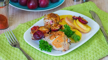 Chicken legs baked in cheese with plums and potatoes