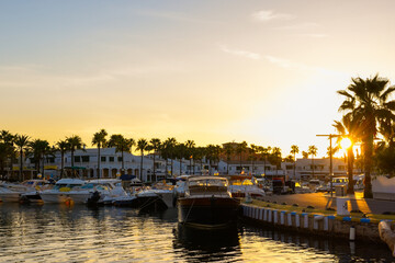 Beautiful sunrise over calm sea water at a tropical marina with luxury boats