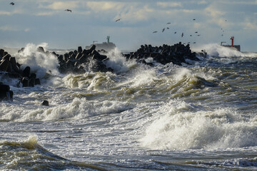 Coastal storm in the baltic sea, big waves crash against the harbor breakwater