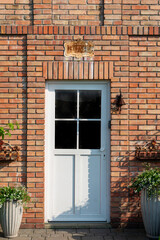 stare przeszklone drzwi do budynku z ceglaną fasadą