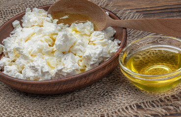 A large bowl with homemade cottage cheese and honey on a wooden table.