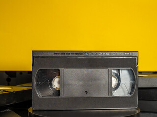 Old VHS cassettes on a yellow background. Retro video cassettes.