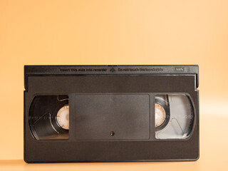 Old VHS cassettes on an orange background. Retro video cassettes.