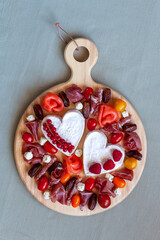 Valentine Day cheese platter with heart shape cheese, delicatessen and fruits