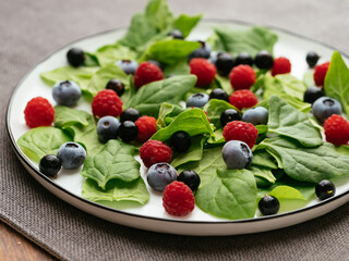 Healthy salad with fresh New Zealand spinach, blueberries, raspberries and blackcurrants
