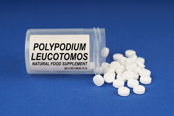 On a blue surface are pills and a dusty jar with the inscription - Polypodium Leucotomos
