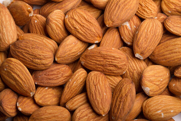 Close up on almonds resting on a flat background.