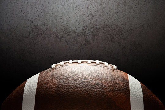 American football ball on rusty iron background with space for text.