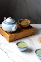 Cups of matcha tea on white background
