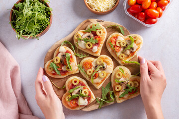 Heart shape mini pizzas on wooden board for Valentines day holiday, top view - obrazy, fototapety, plakaty