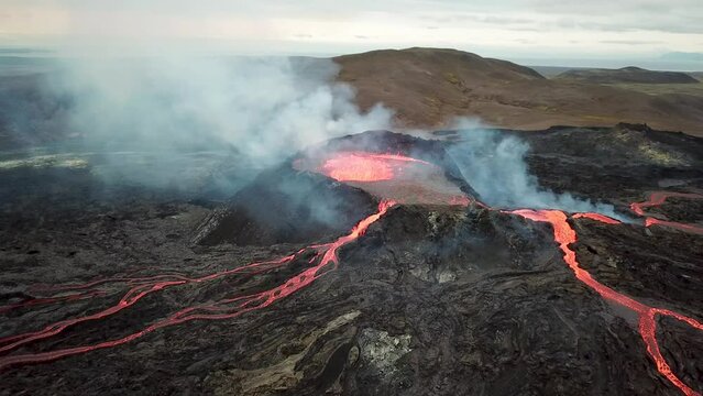 4K Aerial drone footage of Fagradalsfjall active volcano eruption in Geldingadalir, Reykjanes, Iceland. River Of Hot Lava Flowing down the hill surrounded by smoke. Iceland Volcanic eruption Grindavik