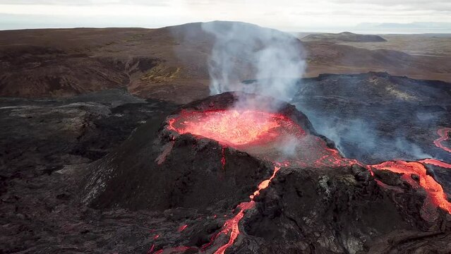 4K Aerial drone footage of Fagradalsfjall active volcano eruption in Geldingadalir, Reykjanes, Iceland. River Of Hot Lava Flowing down the hill surrounded by smoke. Iceland Volcanic eruption Grindavik