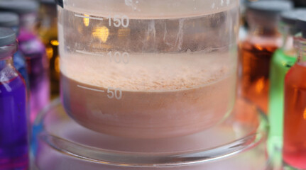 A brown precipitate of manganese sulfide settled at the bottom of the chemical beaker.