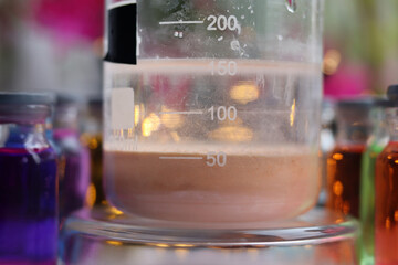 Preparation of a brown insoluble substance of manganese sulfide in a beaker. - obrazy, fototapety, plakaty