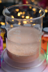 Chemical beaker with brown insoluble manganese sulfide at the bottom.