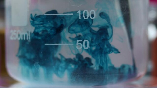 An alkaline solution of crystalline soda turns blue-green when the indicator dye malachite green is added using a measuring pipette.