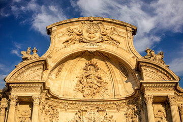 Obraz premium Detail of the upper part of the monumental baroque facade of the cathedral of Murcia, Spain profusely decorated with sculptures and architectural details