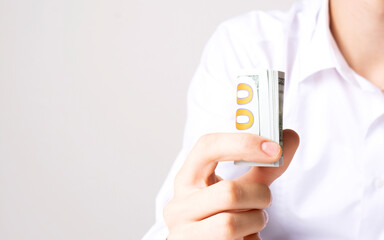 Twisted 100 American dollar bills in a man's hand