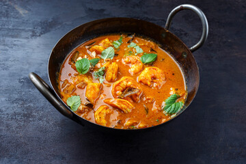 Traditioneller würziges indischer Prawn Madras Curry Rogan Josh mit Riesengarnelen serviert als close-up in einer Korai Schale