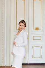 a beautiful and confident woman wearing a white dress and jacket 