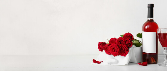 Bottle of wine and rose flowers on white background with space for text. Valentine's Day celebration