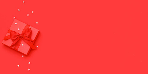 Gift with decor on red background with space for text. Valentines Day celebration