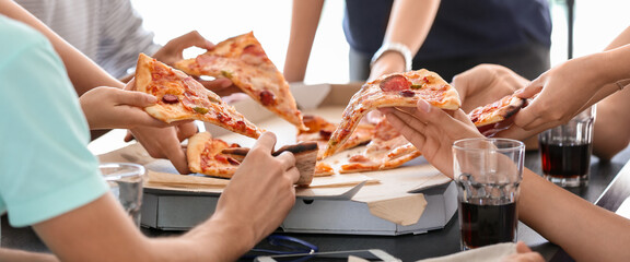 Young people taking slices of hot tasty pizza from cardboard box, closeup