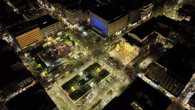 Aerial drone night video of famous neoclassic Municipal Theatre of Piraeus and recently renovated main square of Eleftherias illuminated during Christmas and new year's eve, Attica, Greece
