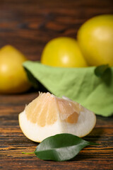 Piece of sweet pomelo fruit on wooden table, closeup