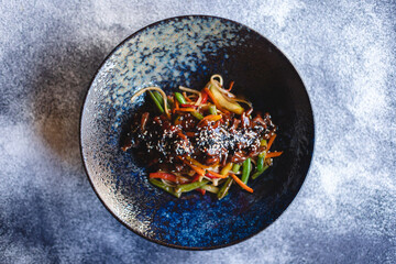 Noodles with seafood and vegetables on a dark background. Asian food.