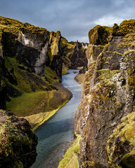 A river runs through the cliffs of Fjadrargljufur, Iceland