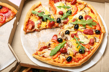 Cardboard box with tasty pizza, closeup