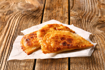 Tasty chebureks on wooden background, closeup