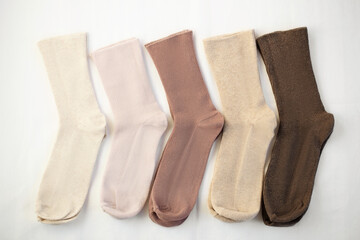 A set of womans socks denim pastel colors laying on white sheets