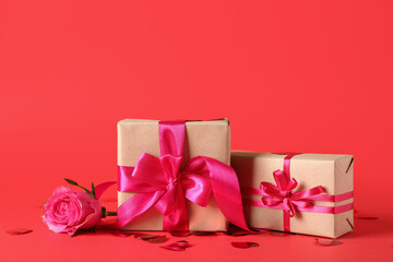Gift boxes with rose flower and confetti on red background. Valentine's Day celebration