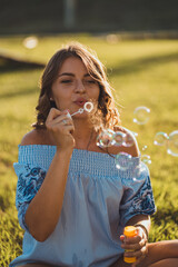 Girl playing with soap bubbles in park