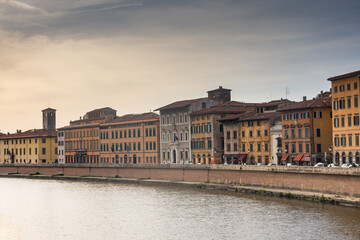 Fototapeta na wymiar Pisa, Italy, 14 April 2022: View of the colorful banks of Arno river