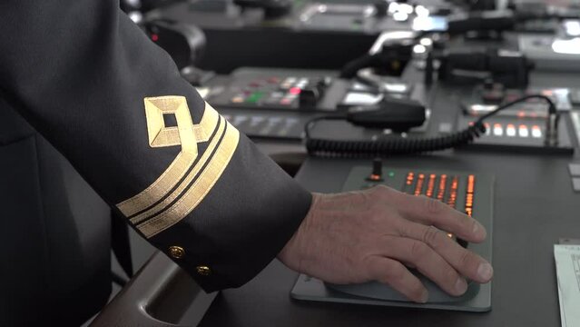 Marine officer's hand presses buttons. Control panel unfocus behind