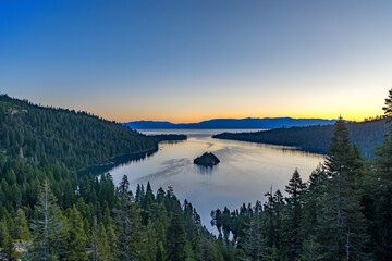 South Lake Tahoe viewed from the mountains with a body of water and small island in the middle with blue sky and room for text