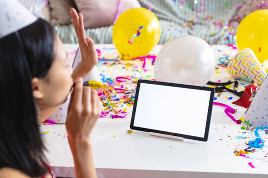 Image of biracial woman using tablet with copy space on screen having party at home
