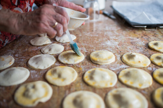 Close up of human hand preparing puff pastry damplings