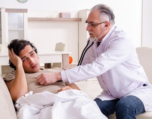 Old male doctor visiting young male patient