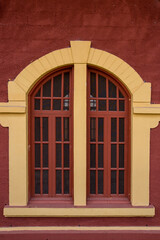Windows with yellow frame on red wall, in old train station in Guararema, Sao Paulo state, Brazil