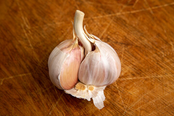 Unpeeled head of garlic isolated on wooden platter
