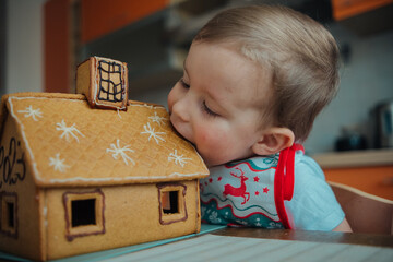 Little boy starting to eat the gingerbread house