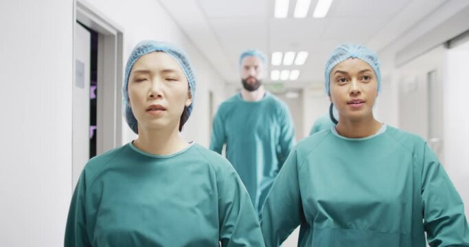 Video Of Four Diverse Surgeons In Surgical Caps And Gowns Walking In Hospital Corridor Talking