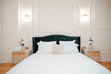 Luxury and stylish bedroom interior with king size bed, white bedding and modern light fixtures and...