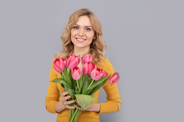 happy girl hold flowers for spring holiday on grey background