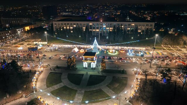 Aerial drone timelapse view of Chisinau at night, Moldova. View of city centre with Christmas decorations, buildings, roads, illumination
