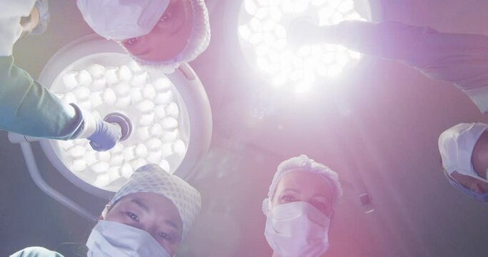Video of patient view looking up at diverse group of surgeons and lights in operating theatre